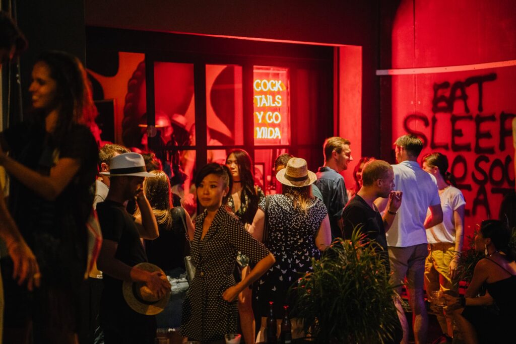 group of people standing waiting outside the bar