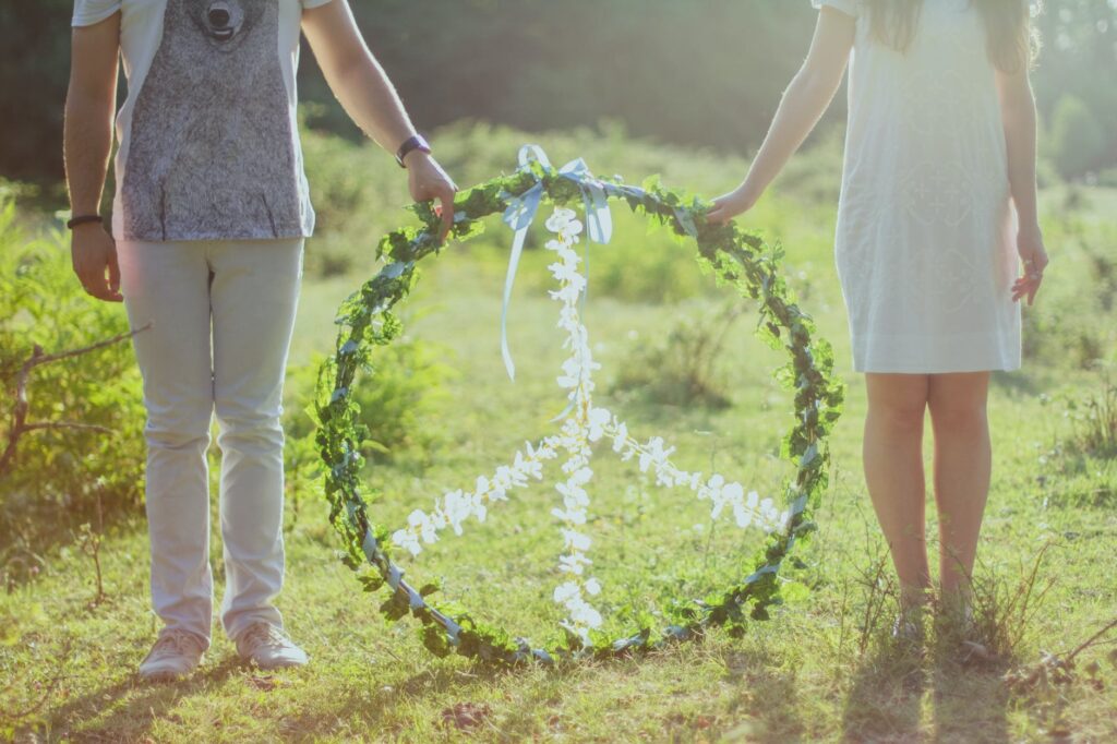 two person holding white and green peace wreath