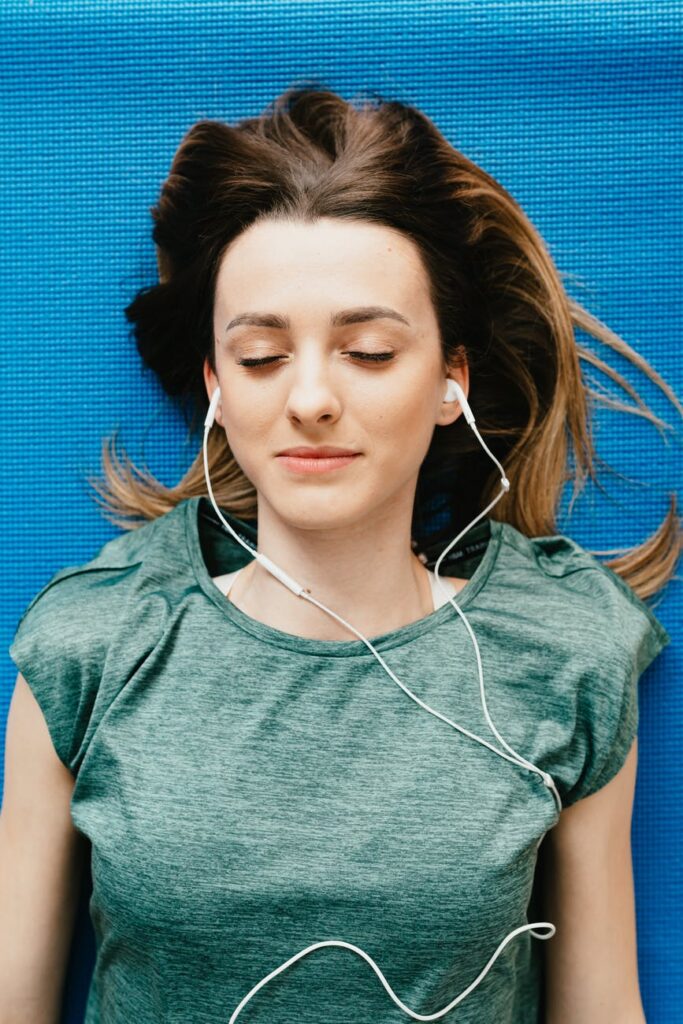 young woman listening to music in earphones in apartment