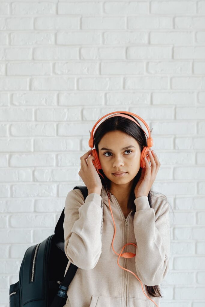 a lady listening to music while holding her headphones