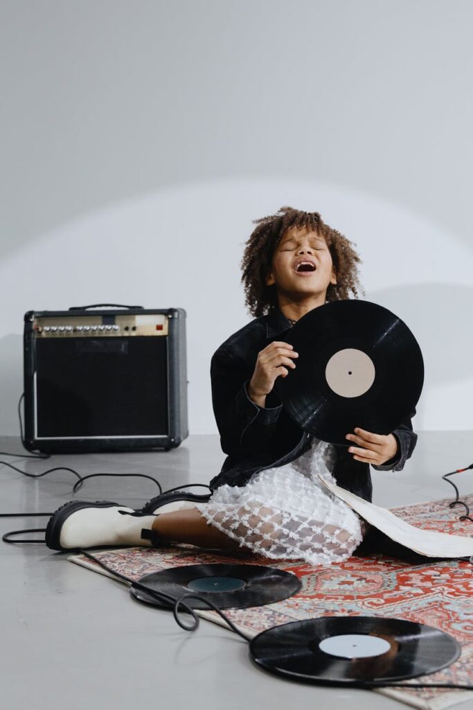 a girl in black long sleeve shirt holding vinyl record