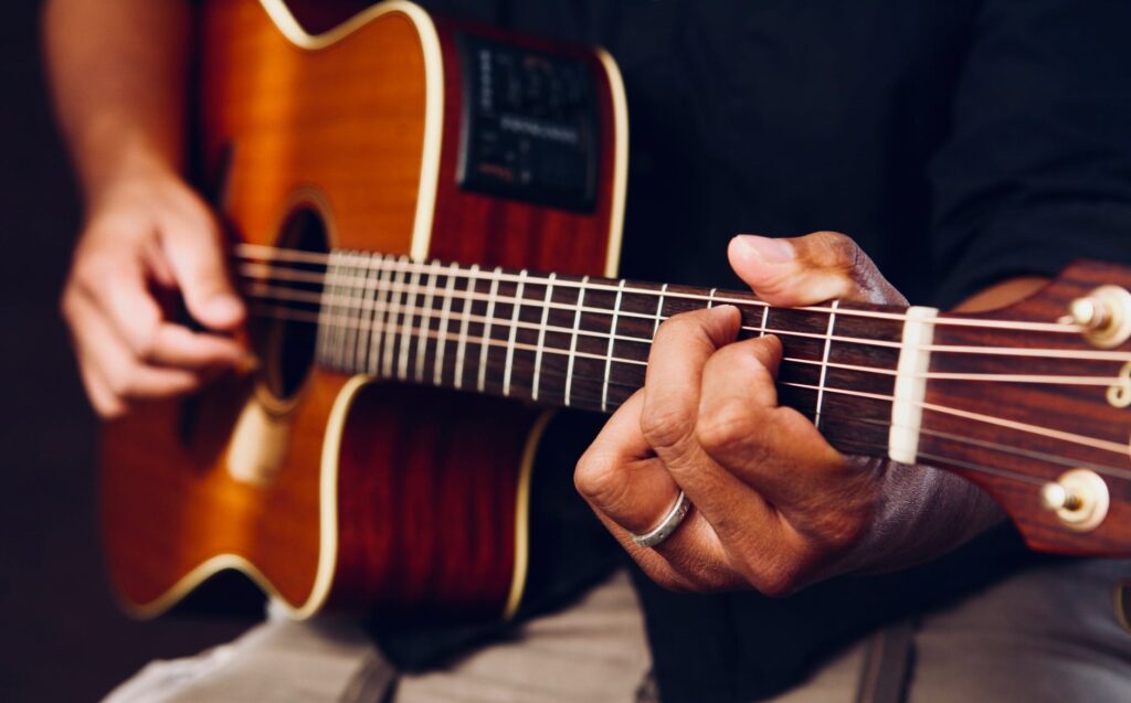 photo of person playing acoustic guitar