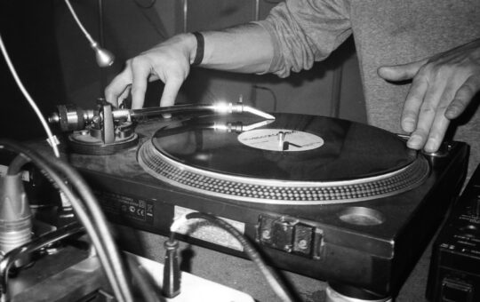 grayscale photography of person playing turntable